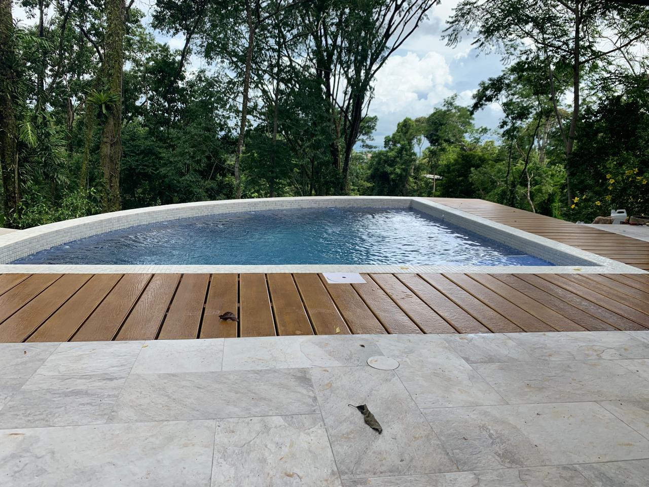 Swimming pool with hardwood deck surrounded by trees